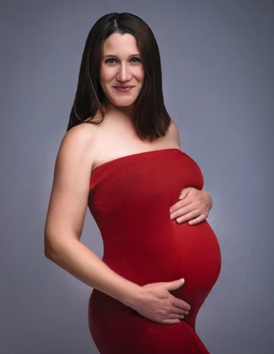 Schwangere Frau im Fotostudio - Babybauch-Fotoshooting in rotem Kleid