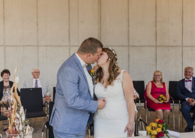 Brautpaar küsst sich vor dem Citrushaus beim Standesamt Ansbach, festgehalten von einem Hochzeitsfotografen