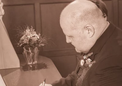 Bräutigam unterschreibt Hochzeitsdokumente im Standesamt, ein entscheidender Moment seiner Hochzeit