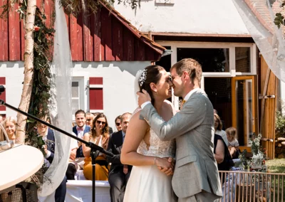 Das Brautpaar lacht herzlich während des Hochzeitskusses