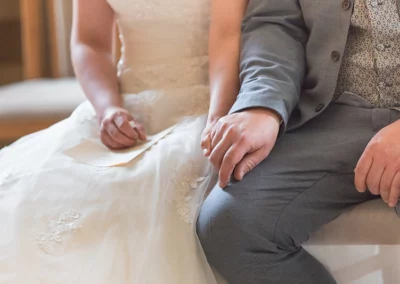 Nahaufnahme des Brautpaares, das bei ihrer Kirchenhochzeit liebevoll Händchen hält