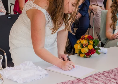 Braut unterzeichnet Hochzeitsdokument im Standesamt