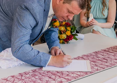 Bräutigam unterschreibt Hochzeitsdokumente im Standesamt